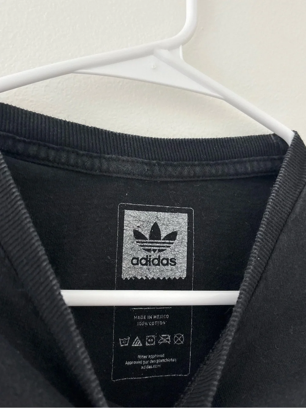 Adidas black t-shirt with white Adidas logo on camouflage background